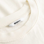 Closeup view of Nikben necklabel on cream colored T-shirt