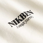 Closeup of black Nikben logo on cream colored T-shirt
