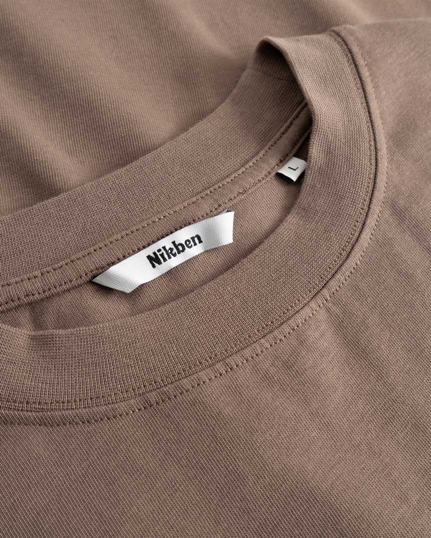 Closeup view of Nikben necklabel on brown T-shirt