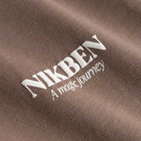 Closeup of white Nikben logo on brown T-shirt