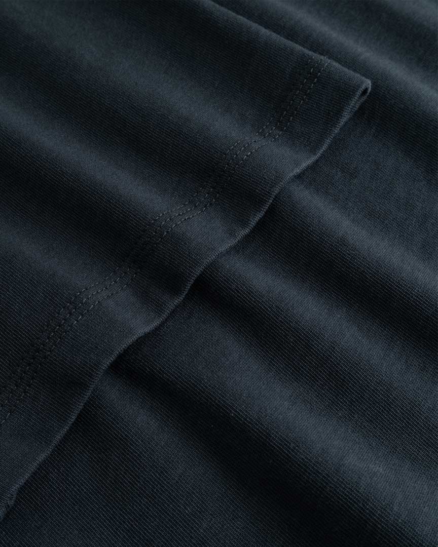 Closeup view of arm stitchings on black T-shirt