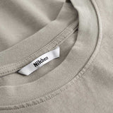 Closeup view of Nikben necklabel on beige T-shirt