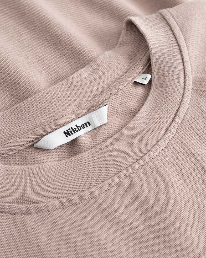 Closeup view of Nikben necklabel on beige T-shirt