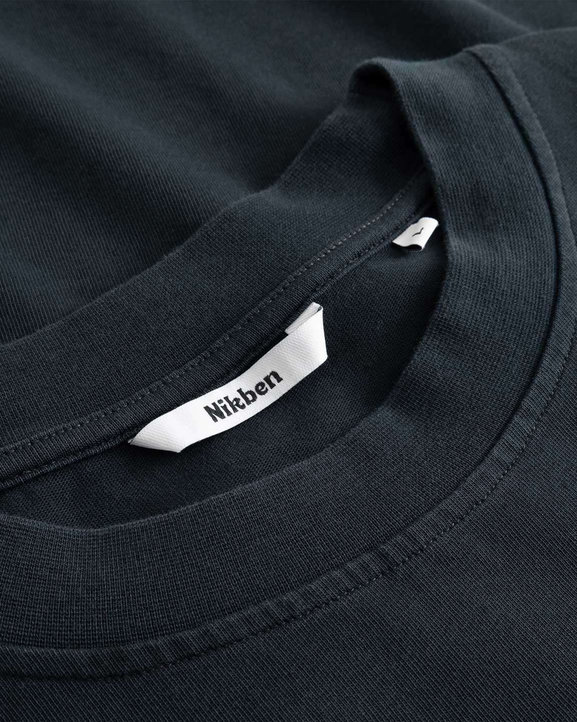 Closeup view of Nikben necklabel on black T-shirt