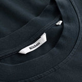 Closeup view of Nikben necklabel on black T-shirt