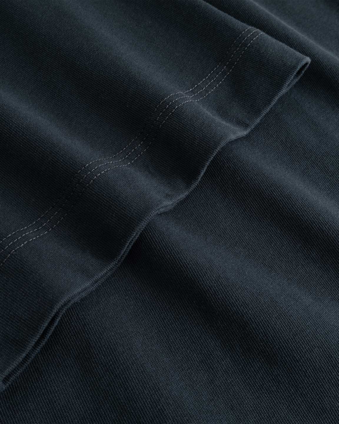 Closeup view of arm stitchings on black T-shirt