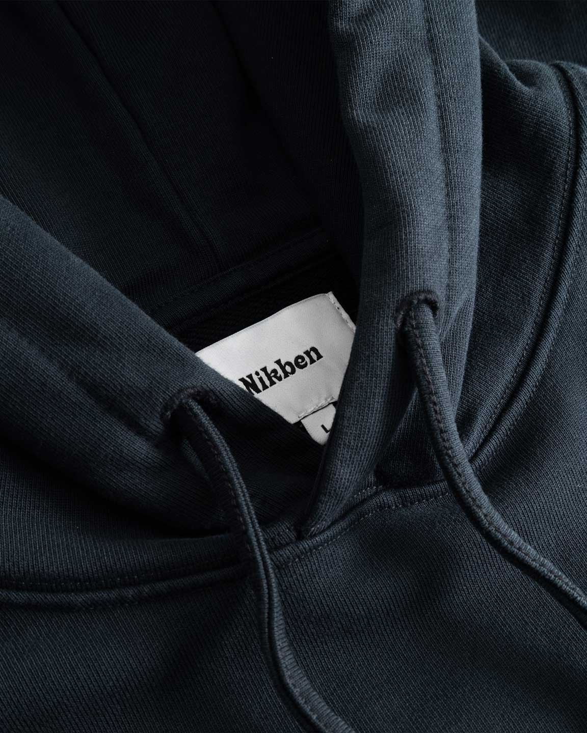 Closeup view of Nikben necklabel on black hoodie