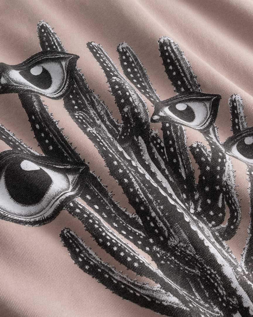 Closeup view of black and white cactus print on brown hoodie