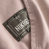 Closeup view of green Nikben patch logo next to left pocket on brown hoodie 