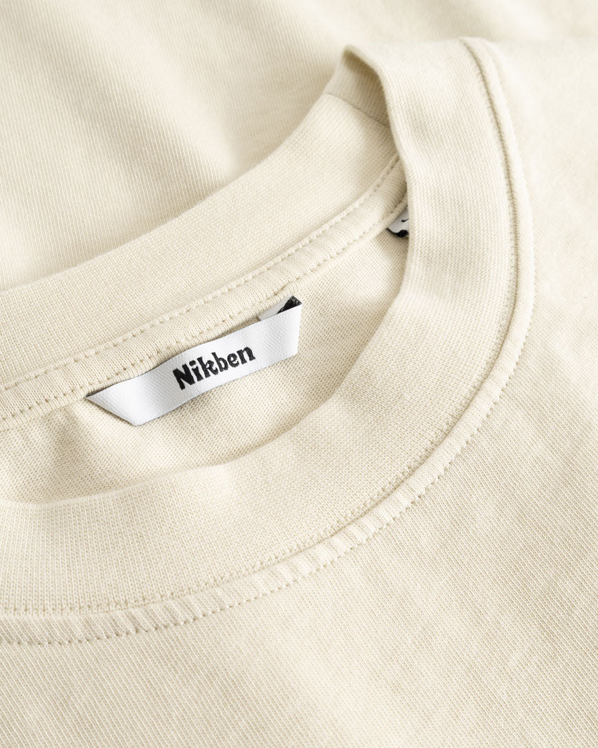 Closeup view of Nikben necklabel on beige T-shirt
