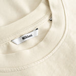 Closeup view of Nikben necklabel on beige T-shirt