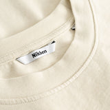 Closeup view of Nikben necklabel on beige T-shirt