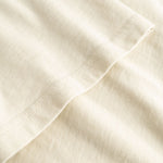 Closeup view of arm stitchings on beige T-shirt