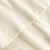 Closeup view of arm stitchings on beige T-shirt
