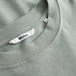 Closeup view of Nikben necklabel on green T-shirt