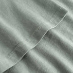 Closeup view of arm stitchings on green T-shirt