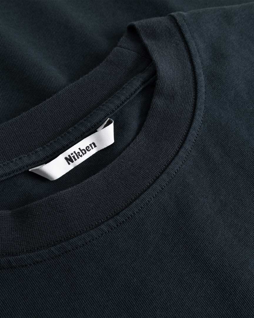 Closeup view of Nikben necklabel on black T-shirt
