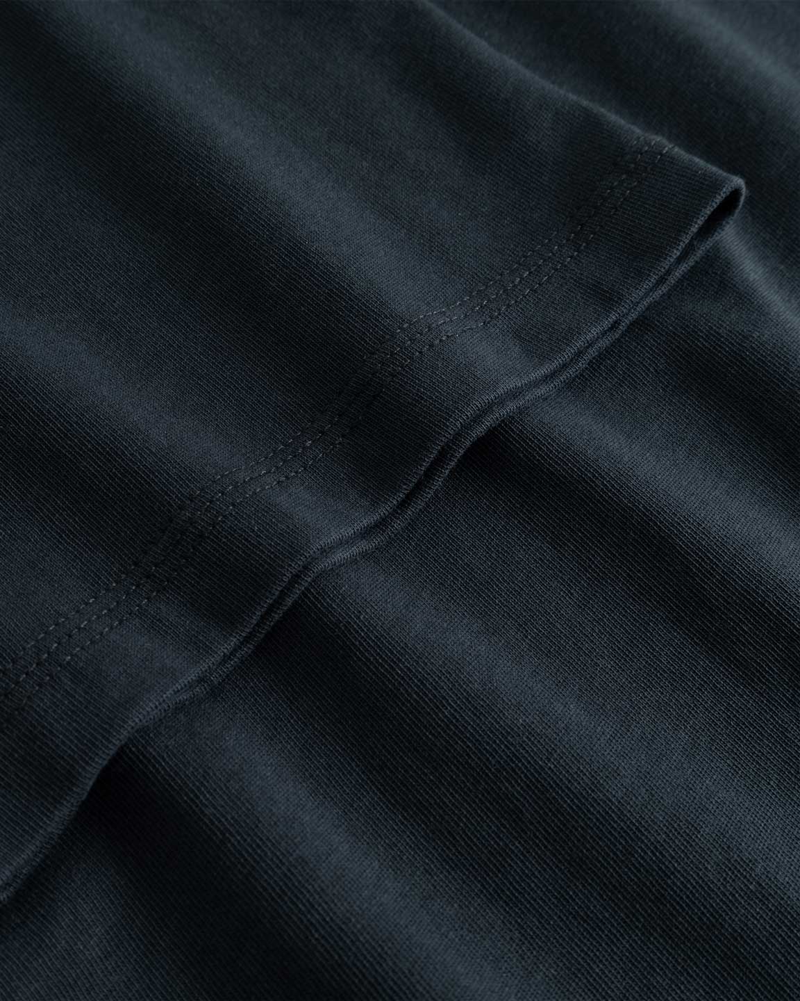 Closeup view of arm stitchings on black T-shirt