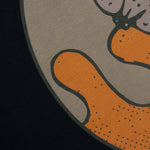 Closeup view of green and orange print on back of black T-shirt