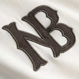 Closeup view of brown NB logo on white longsleeve T-shirt