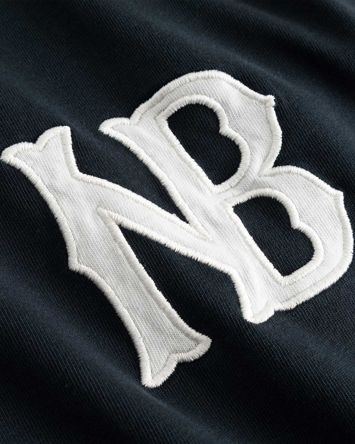 Closeup view of white NB logo on black longsleeve T-shirt