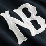 Closeup view of white NB logo on black longsleeve T-shirt