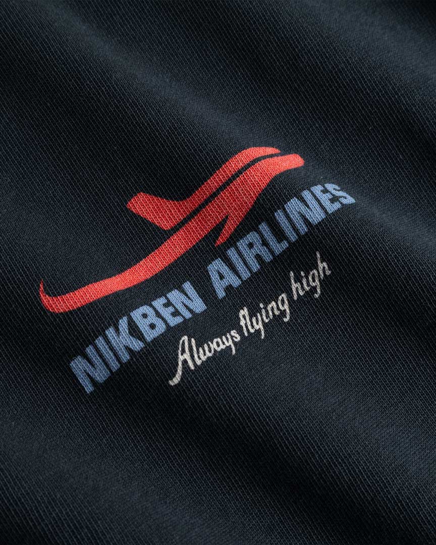 Closeup view of blue Nikben Airlines logo and red airplane print on black T-shirt