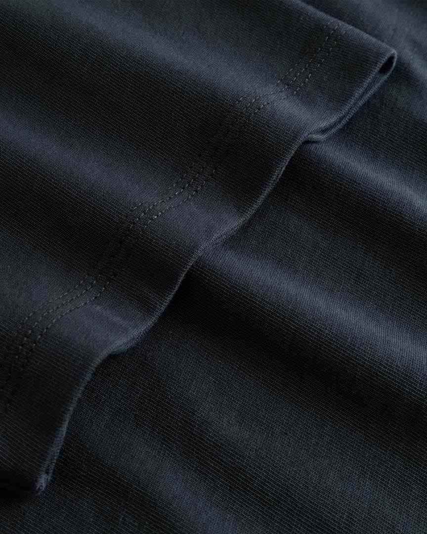 Closeup view of arm stitchings on black T-shirt