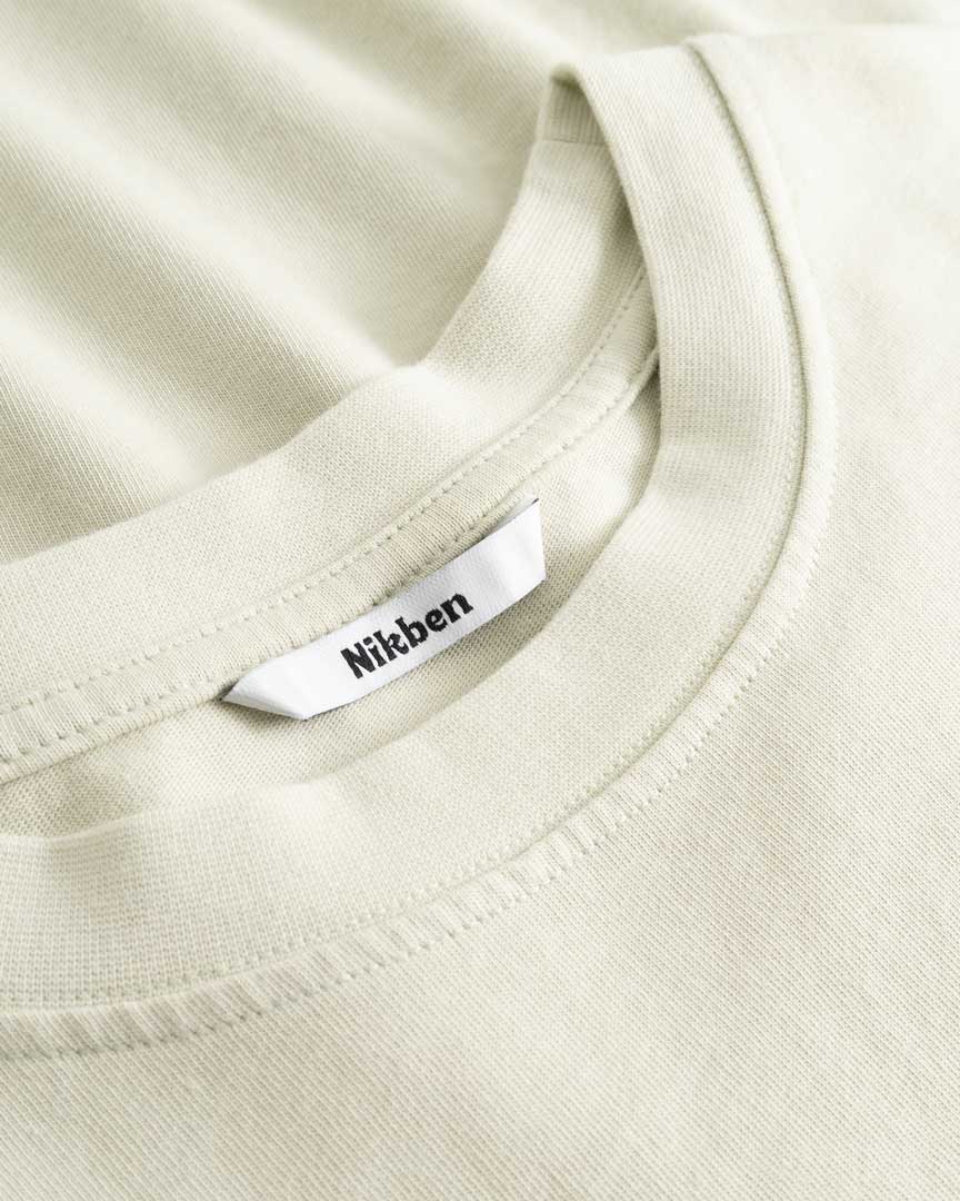 Closeup view of Nikben necklabel on light grey T-shirt