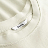 Closeup view of Nikben necklabel on light grey T-shirt