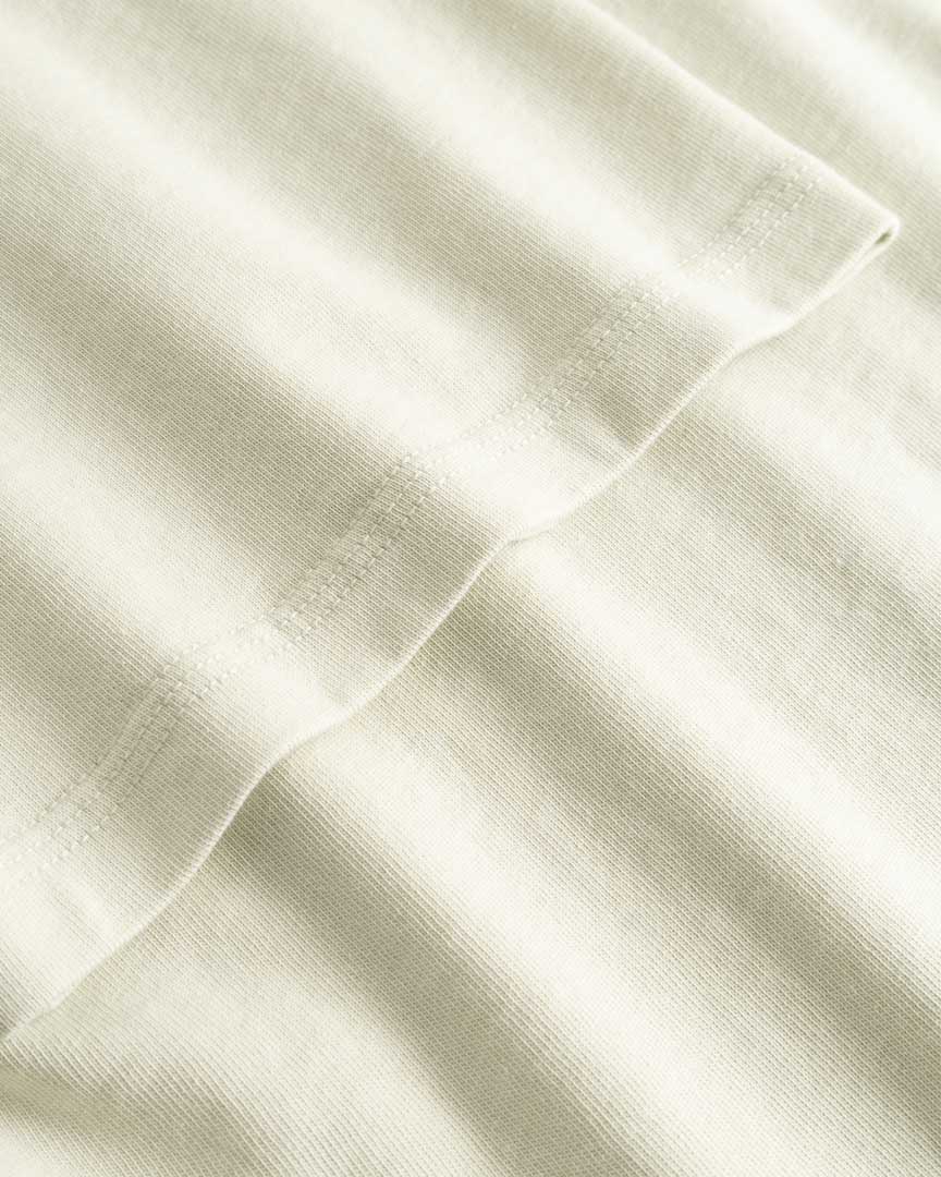 Closeup view of arm stitchings on light grey T-shirt