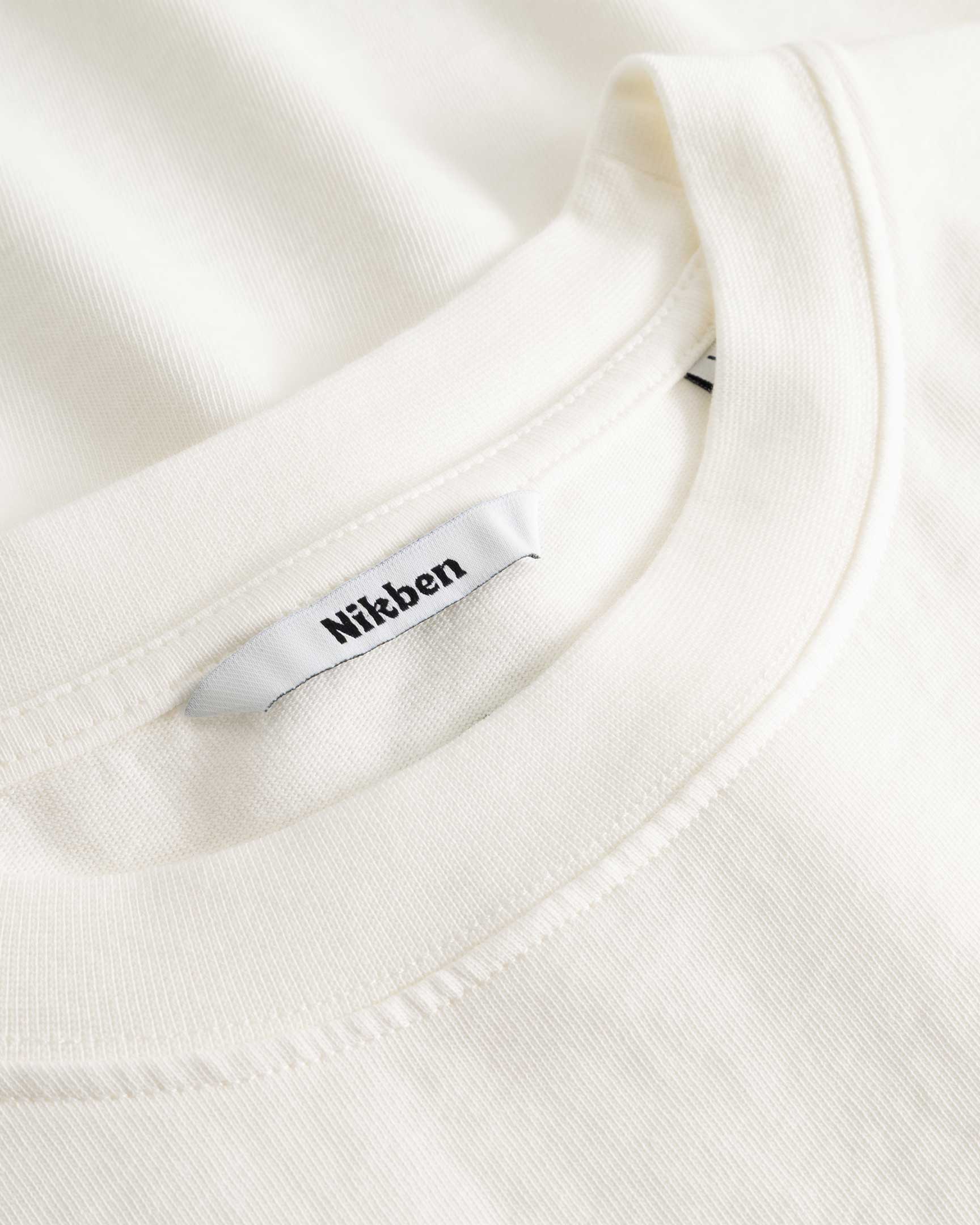 Closeup view of Nikben necklabel on white T-shirt