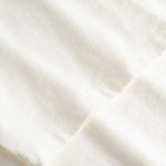 Closeup view of arm stitchings on white T-shirt
