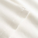 Closeup view of bottom hem on white ribbed tank top