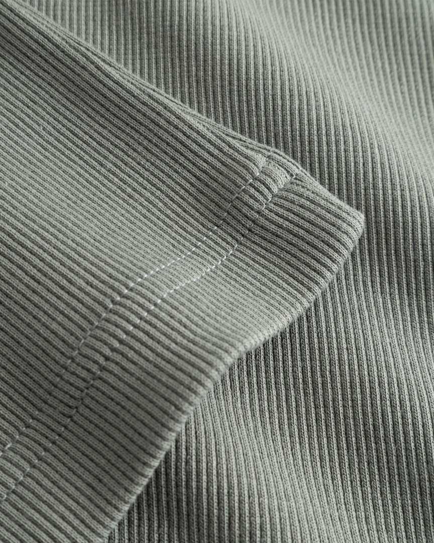 Closeup view of bottom hem on green ribbed tank top
