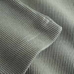 Closeup view of bottom hem on green ribbed tank top