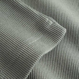 Closeup view of bottom hem on green ribbed tank top