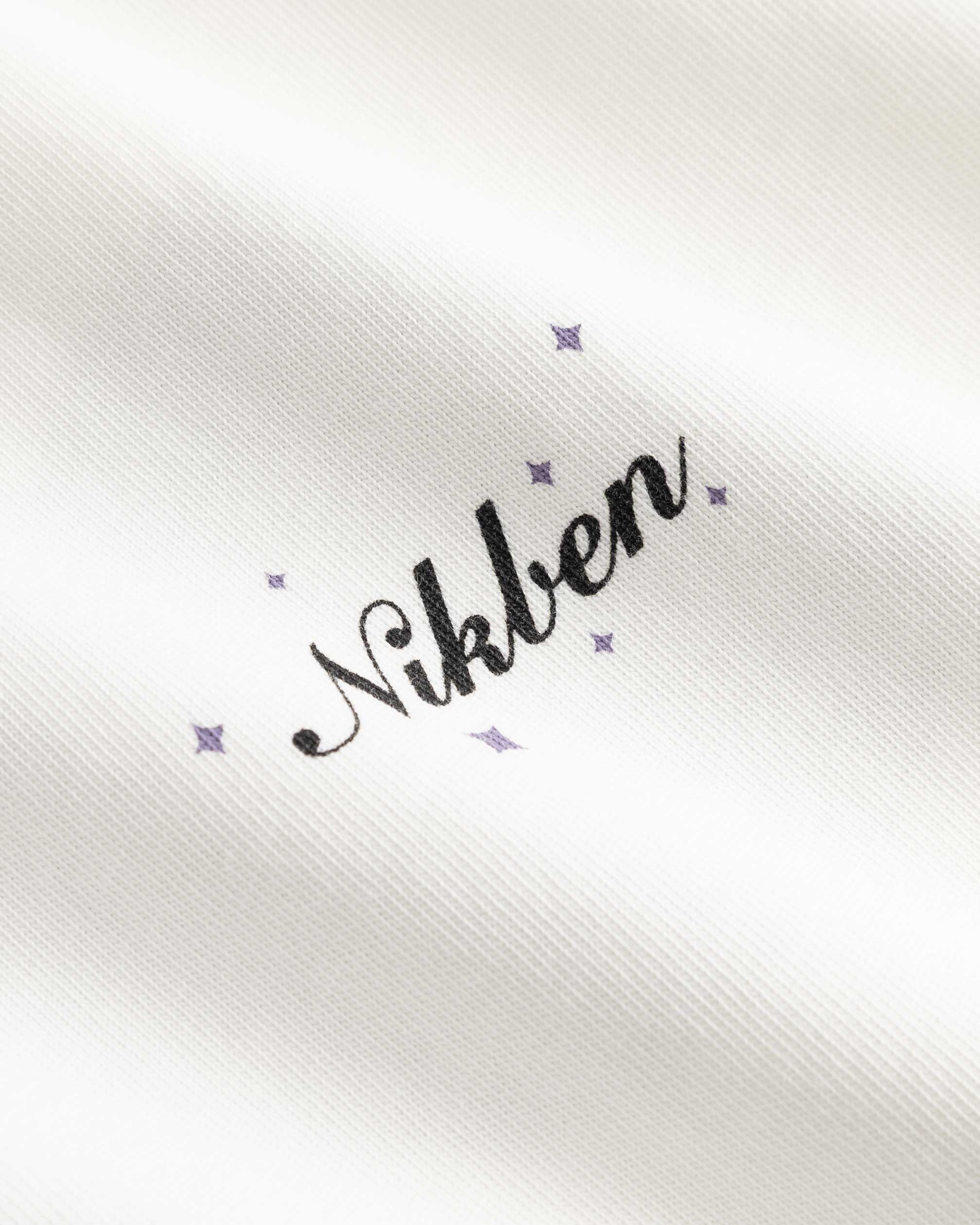 Closeup view of black Nikben logo on white T-shirt