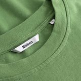 Closeup view of Nikben necklabel on green T-shirt