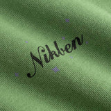 Closeup view of black Nikben logo on green T-shirt