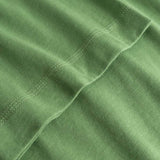 Closeup view of arm stitchings on green T-shirt
