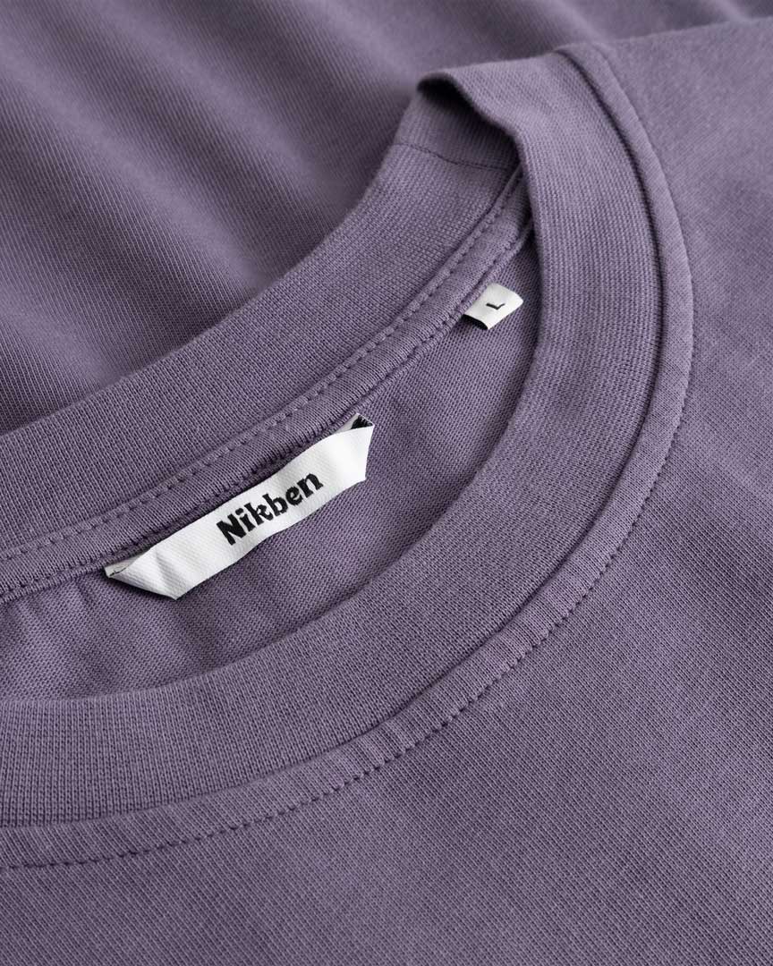 Closeup view of Nikben necklabel on purple T-shirt