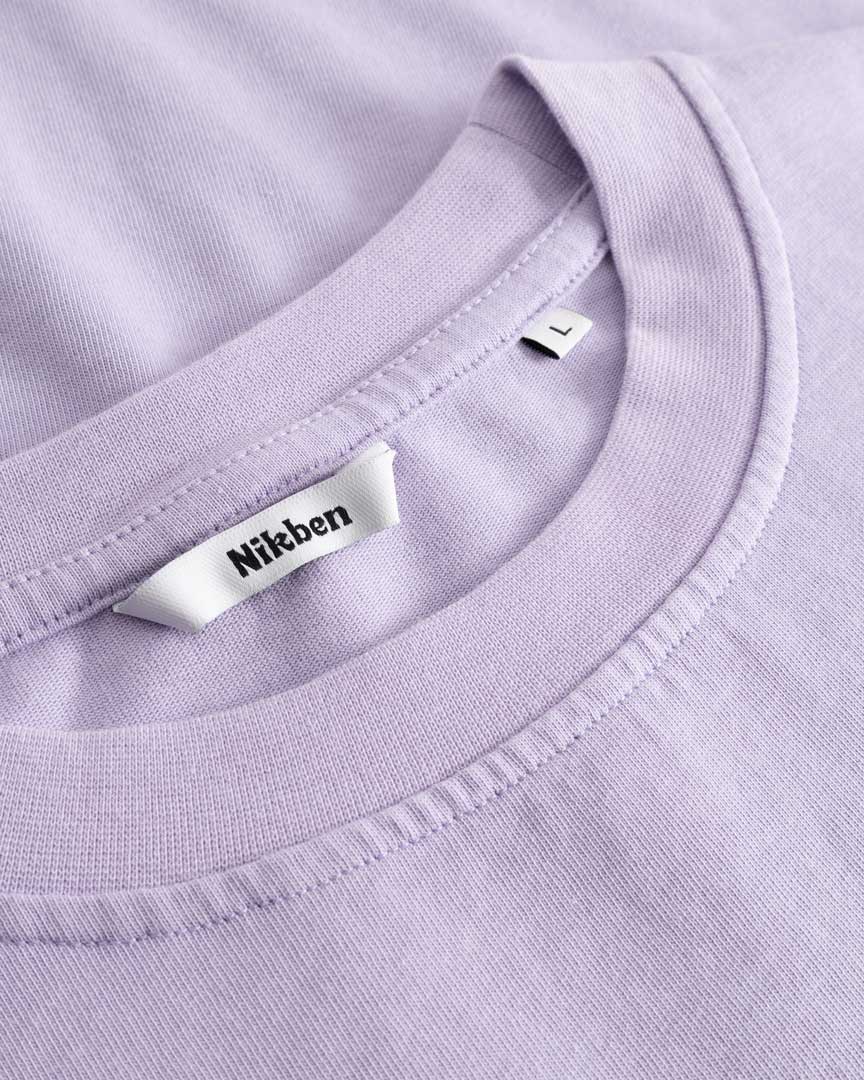 Closeup view of Nikben necklabel on light purple T-shirt