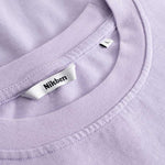 Closeup view of Nikben necklabel on light purple T-shirt