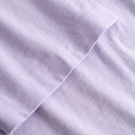 Closeup view of arm stitchings on light purple T-shirt