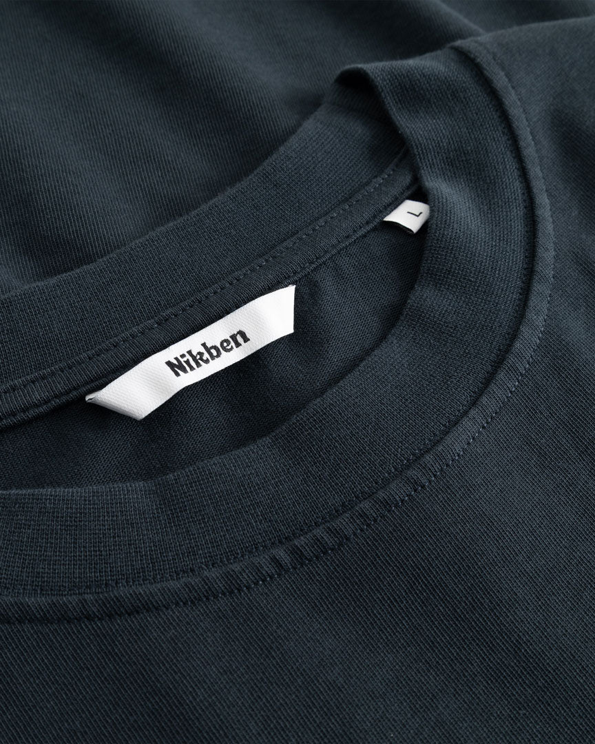 Closeup view of Nikben necklabel on black T-shirt