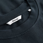 Closeup view of Nikben necklabel on black T-shirt