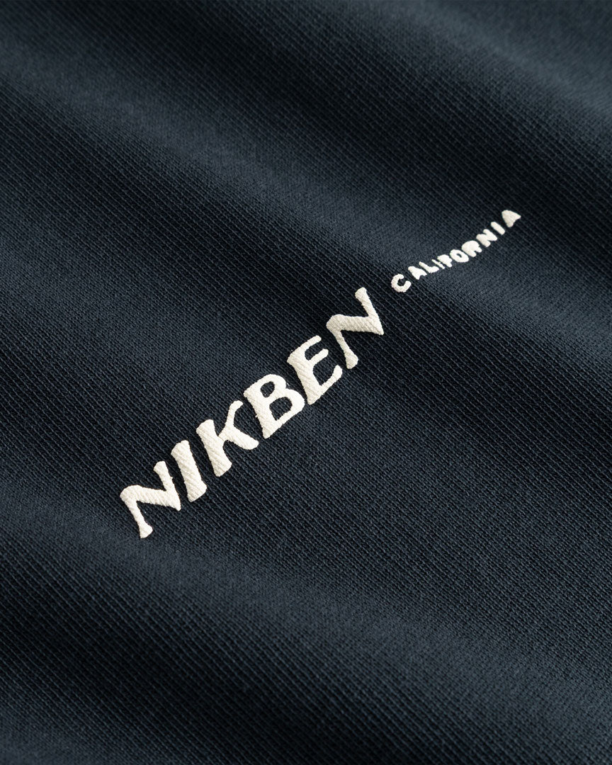 Closeup view of white "Nikben California" logo on black T-shirt