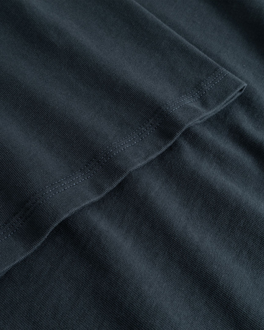 Closeup view of arm stitchings on black T-shirt