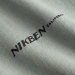 Closeup view of black "Nikben California" logo on grey T-shirt